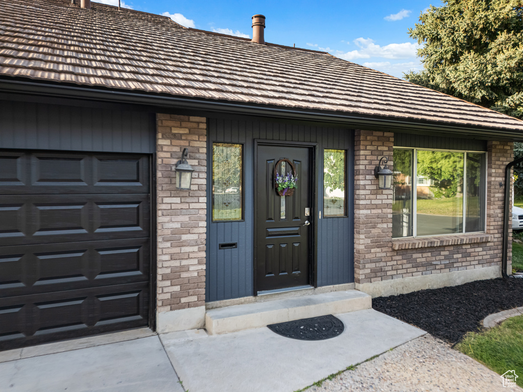 Entrance to property featuring brick siding and driveway