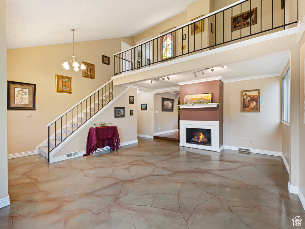 Unfurnished living room with stairs, a chandelier, baseboards, a lit fireplace, and marble finish floors