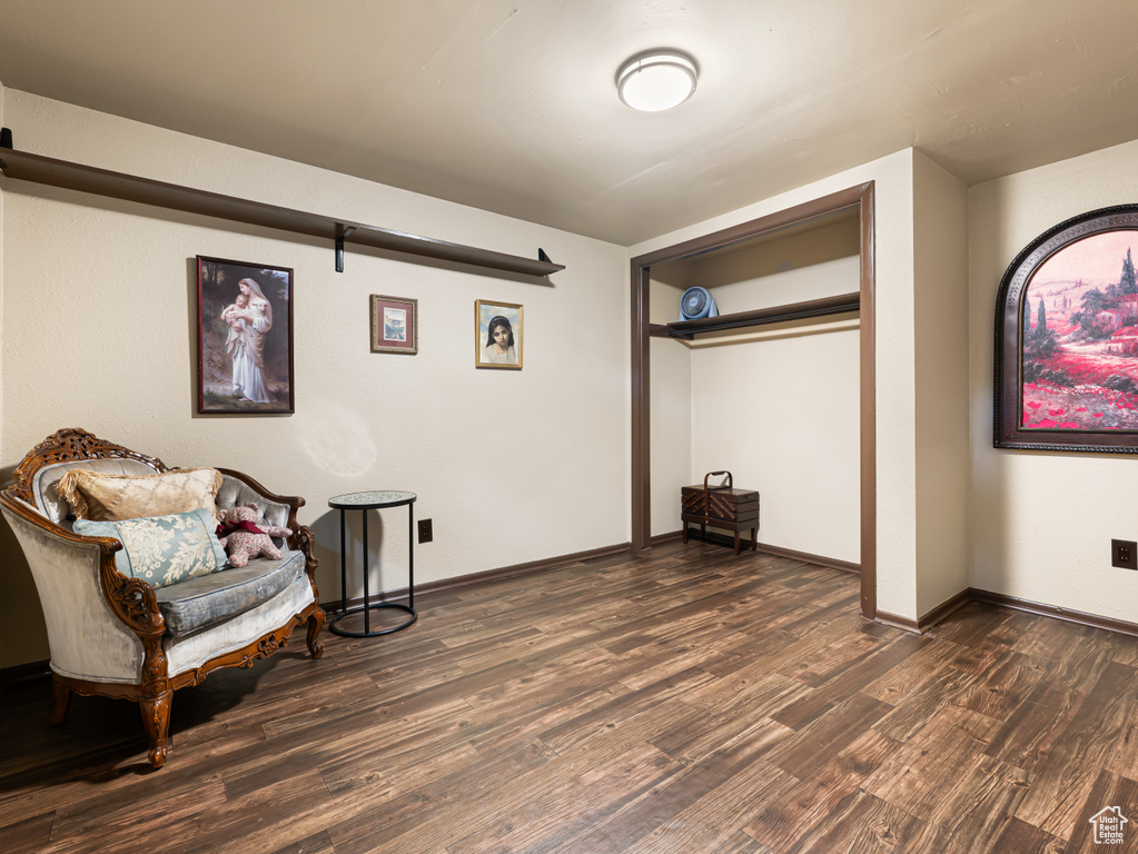 Sitting room with dark wood-type flooring and baseboards