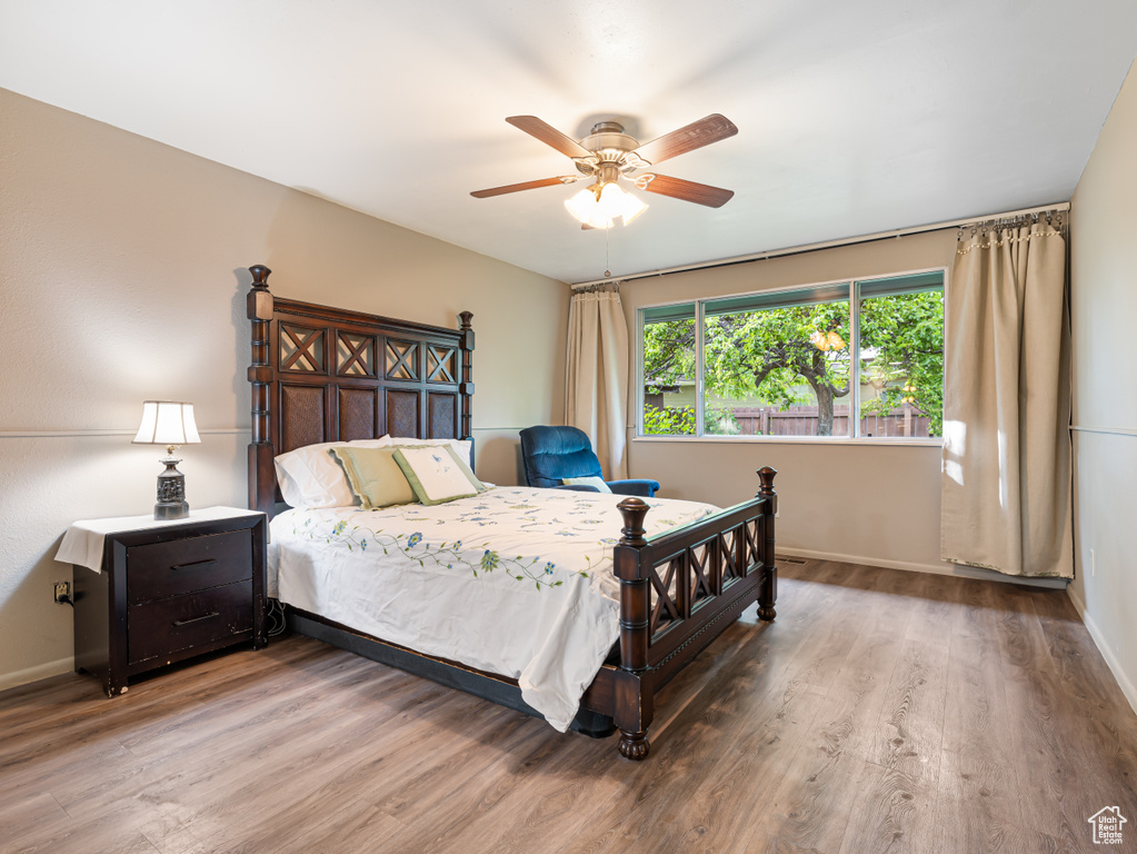 Bedroom with wood finished floors, baseboards, and ceiling fan