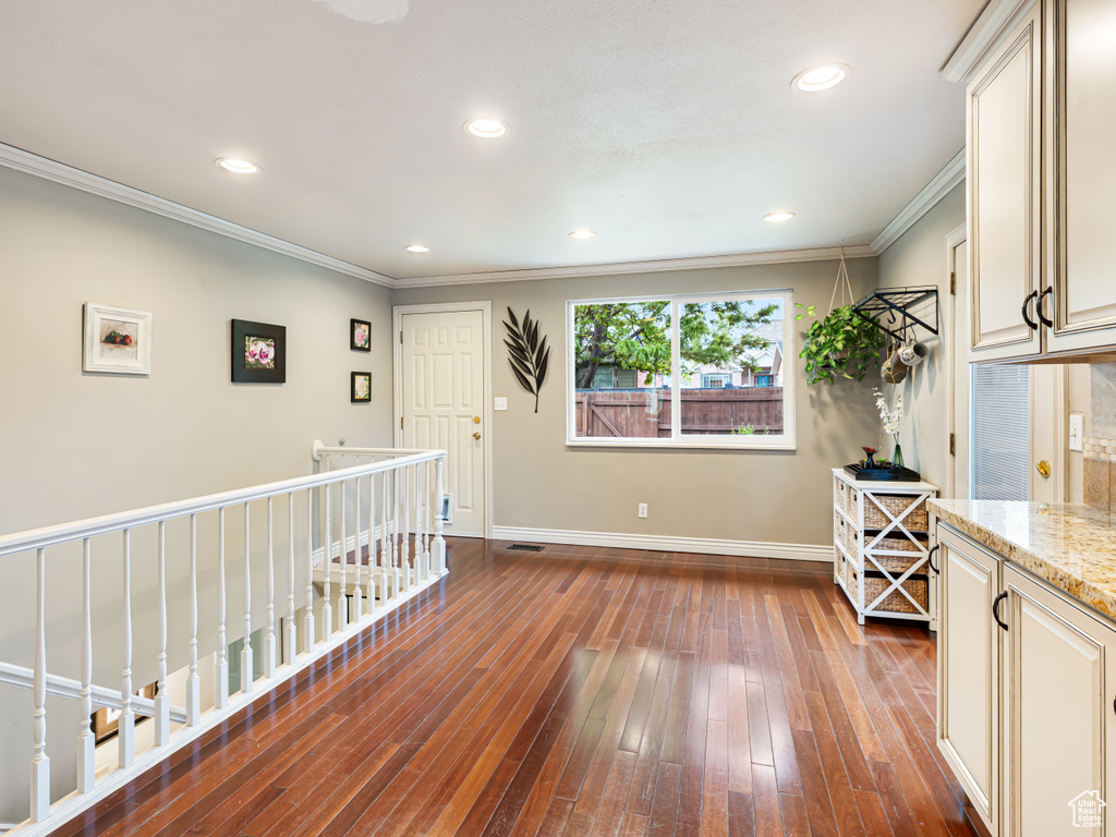 Corridor featuring dark wood-style flooring, baseboards, crown molding, and recessed lighting