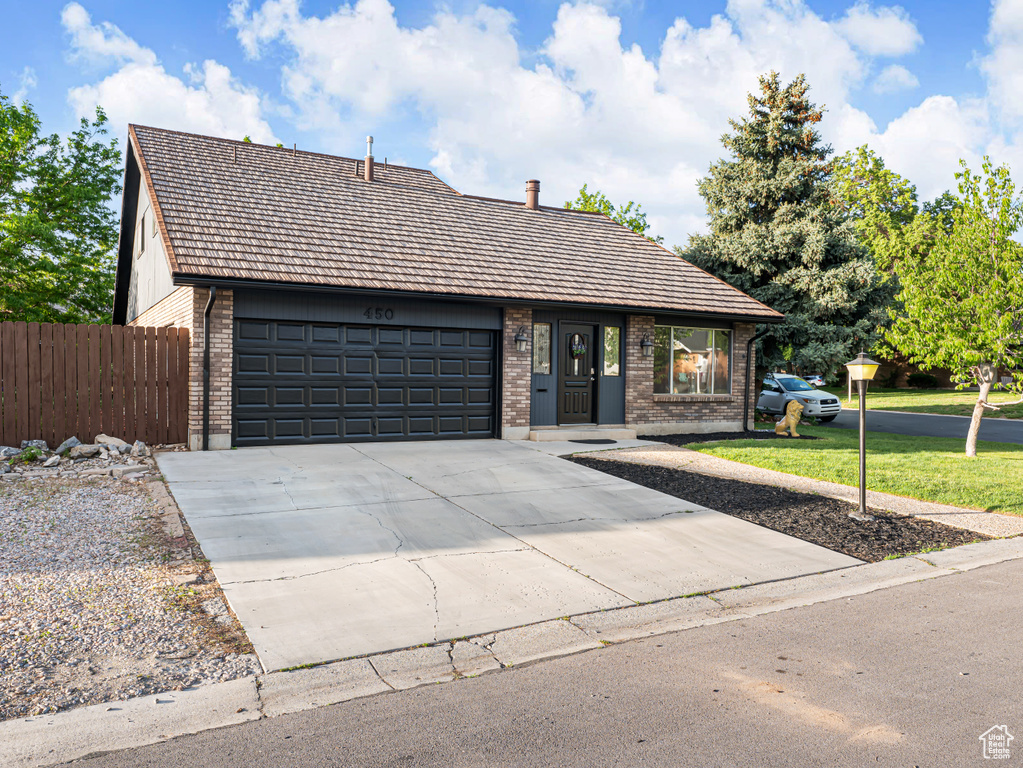 View of front of home featuring brick siding, a garage, and concrete driveway