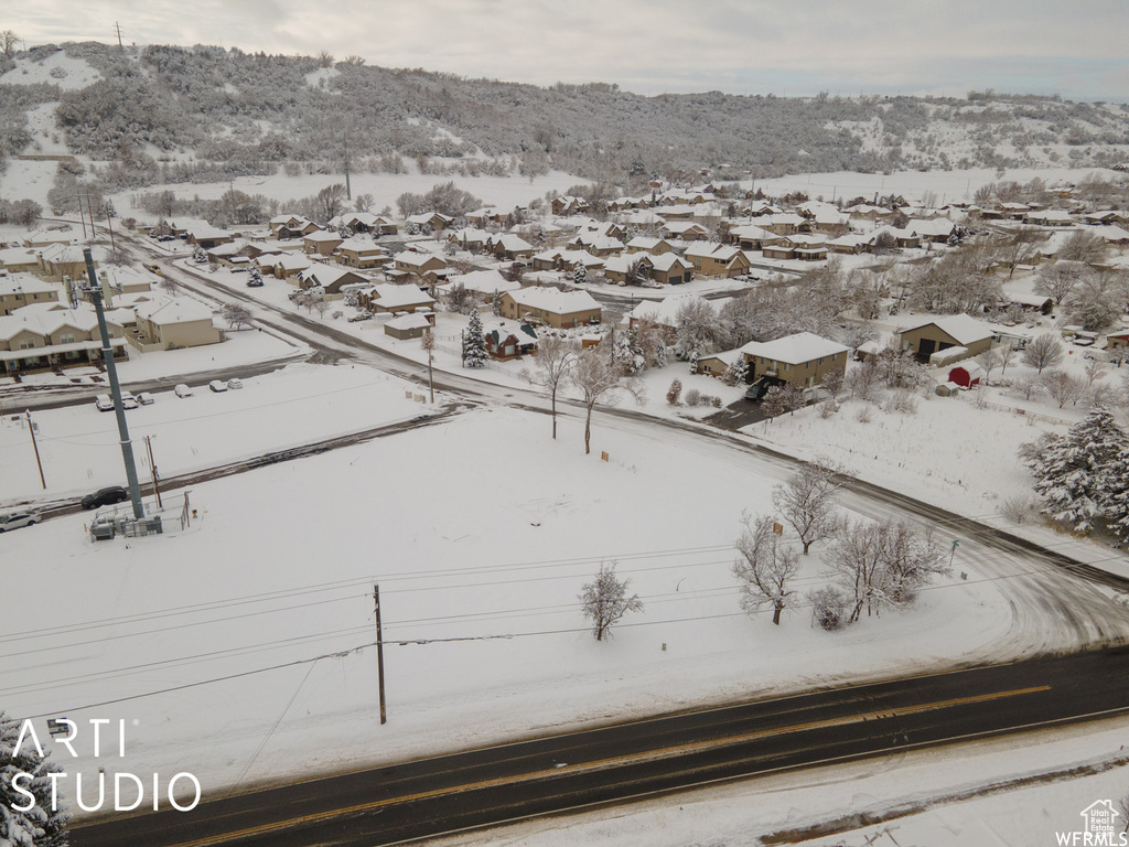 Snowy aerial view featuring a residential view and a mountain view