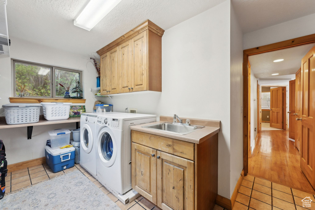 Laundry room with cabinet space, washer and clothes dryer, light tile patterned flooring, baseboards, and recessed lighting