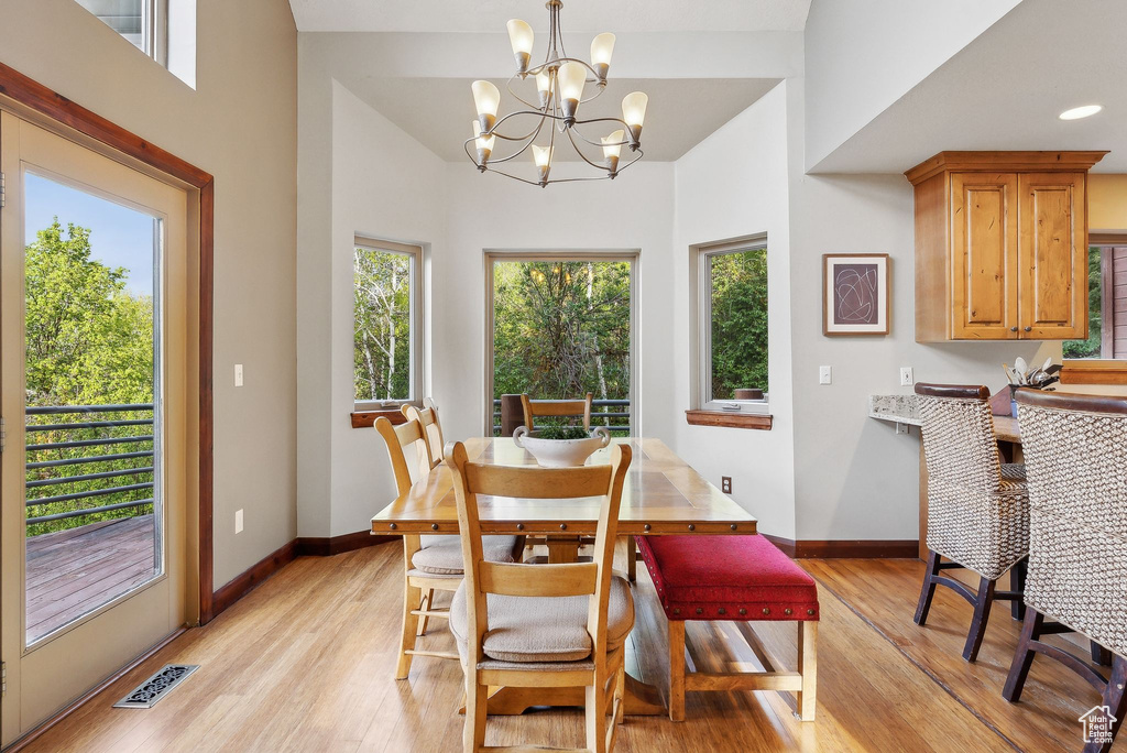 Dining room featuring light wood-type flooring, baseboards, and a chandelier