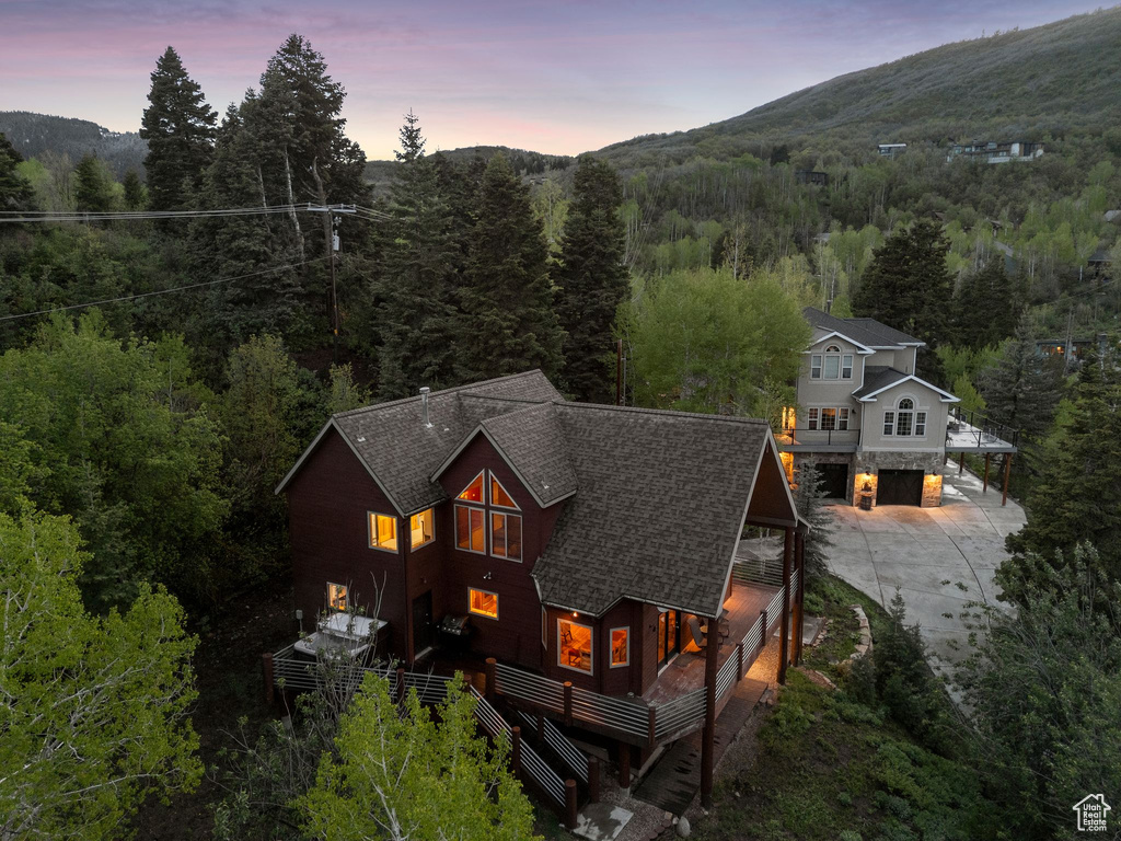 View of subject property featuring a heavily wooded area and mountains