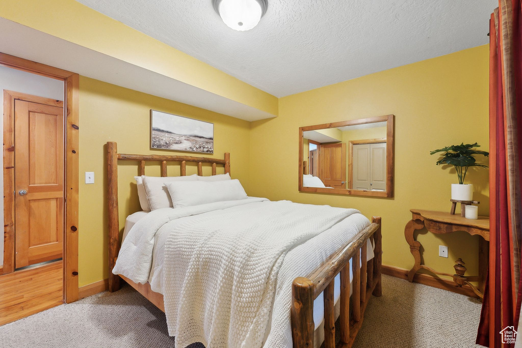 Bedroom featuring a textured ceiling, carpet floors, and baseboards