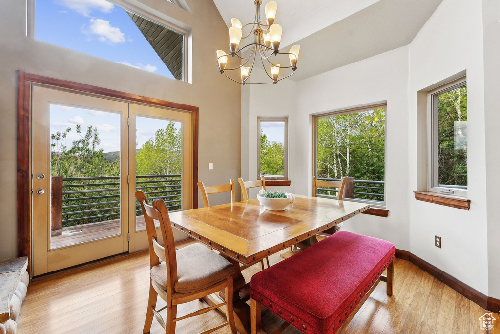 Dining space featuring light wood-type flooring, a chandelier, and baseboards