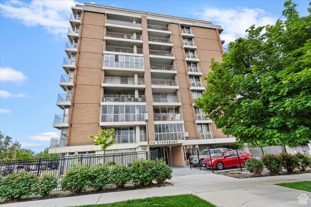 View of apartment building / complex featuring fence