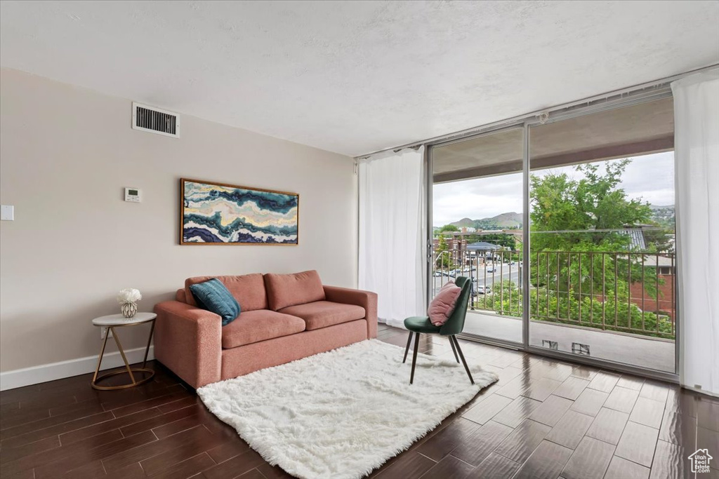 Living room featuring expansive windows, wood tiled floors, and baseboards