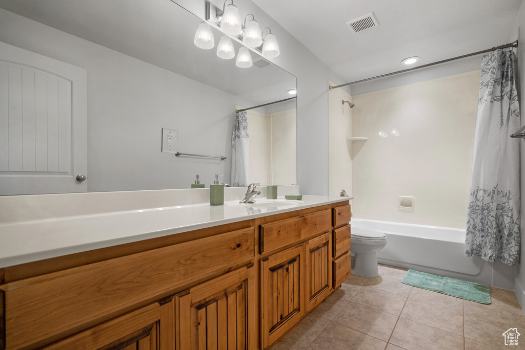 Full bathroom with tile patterned floors, toilet, shower / bathtub combination with curtain, and vanity
