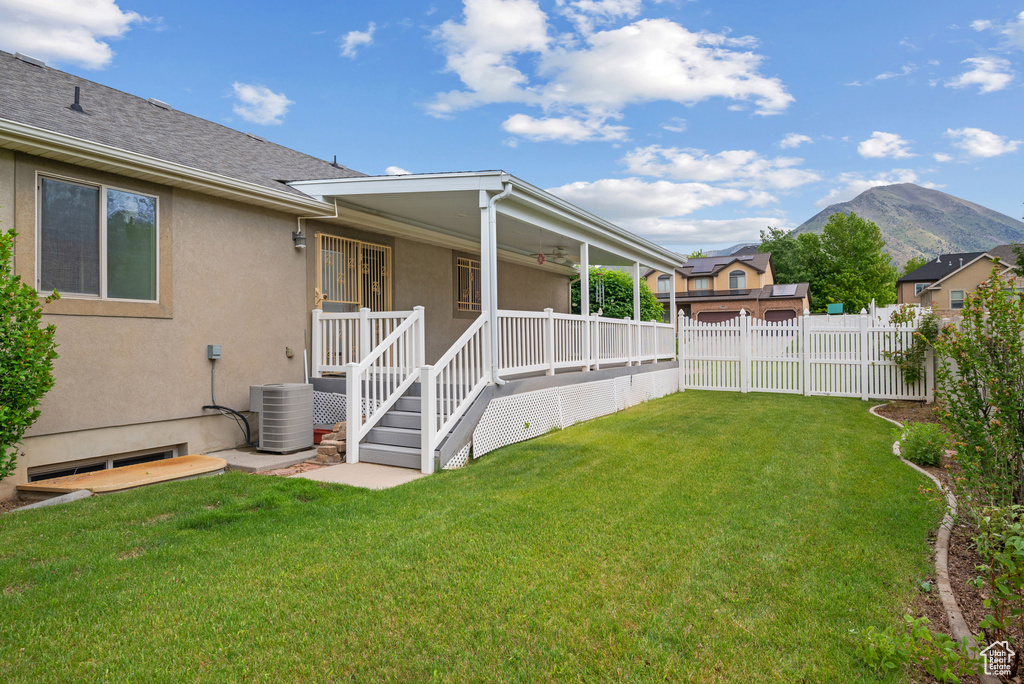 View of yard featuring central AC unit, a mountain view, and covered porch
