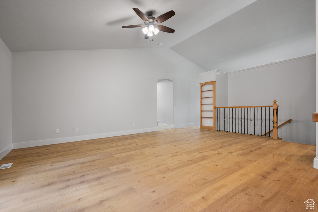 Bonus room with ceiling fan, vaulted ceiling, light wood finished floors, arched walkways, and baseboards