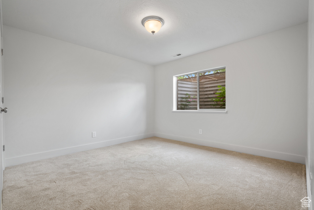 Carpeted empty room with baseboards