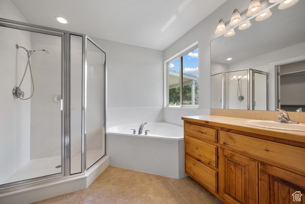 Bathroom with a shower stall, tile patterned flooring, vanity, a bath, and recessed lighting
