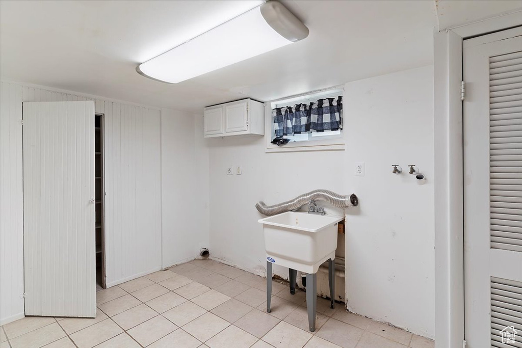 Washroom featuring cabinet space and light tile patterned floors