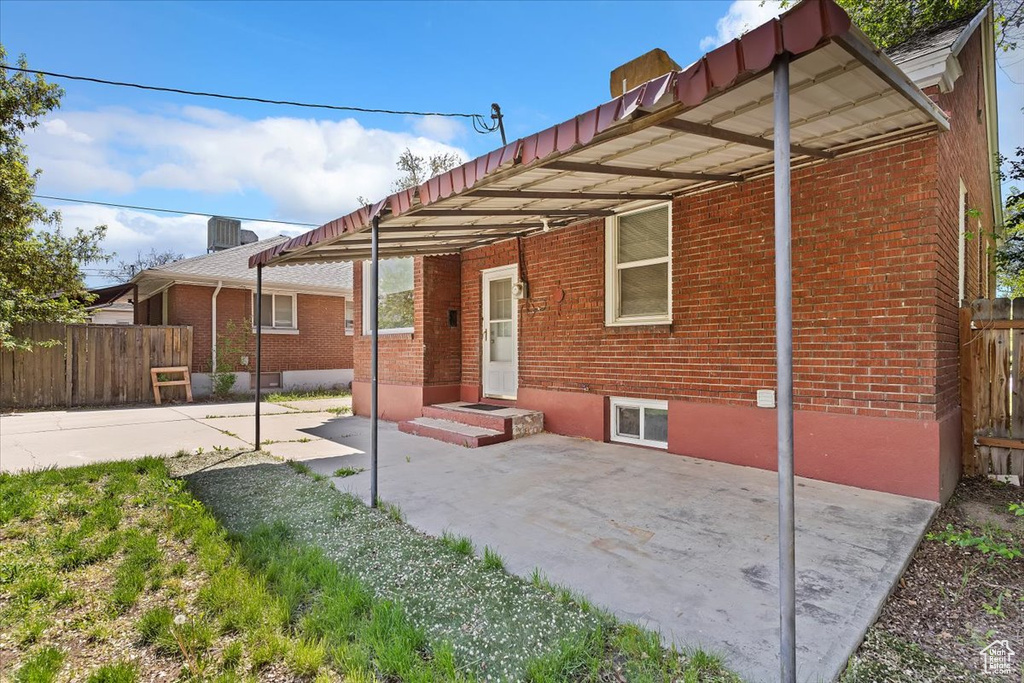 Back of house featuring brick siding and fence
