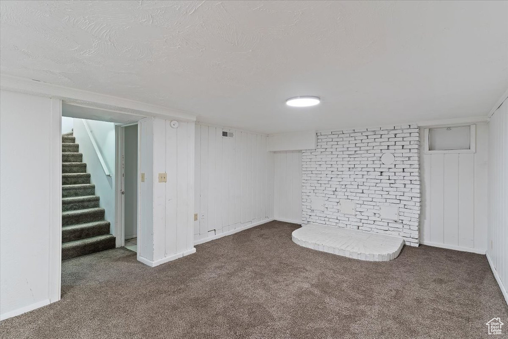 Finished basement featuring carpet floors, stairs, and a textured ceiling