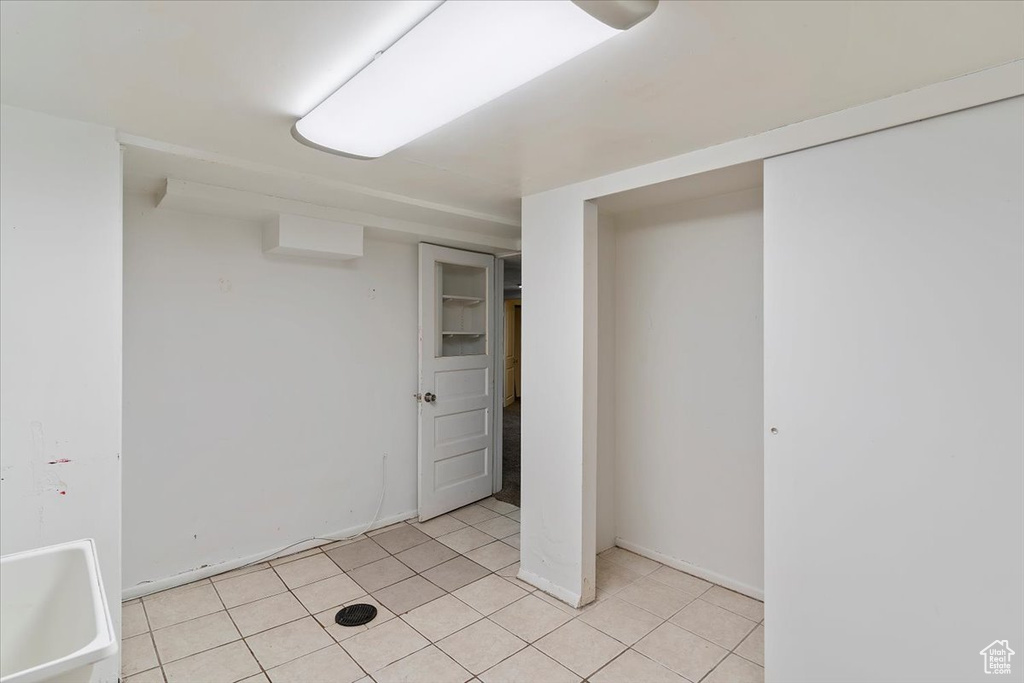 Unfurnished bedroom with a closet, light tile patterned floors, and baseboards