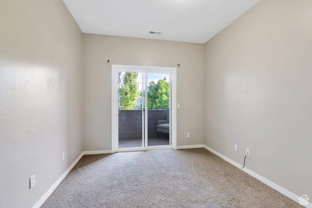 Empty room featuring carpet flooring and baseboards