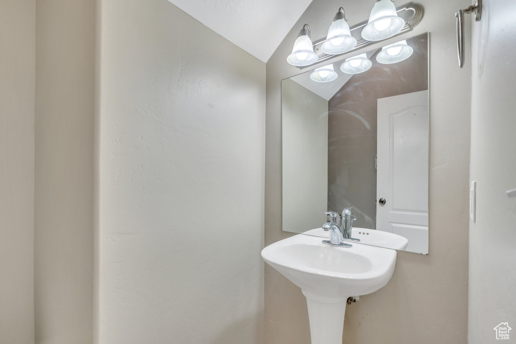 Bathroom with vaulted ceiling and a sink