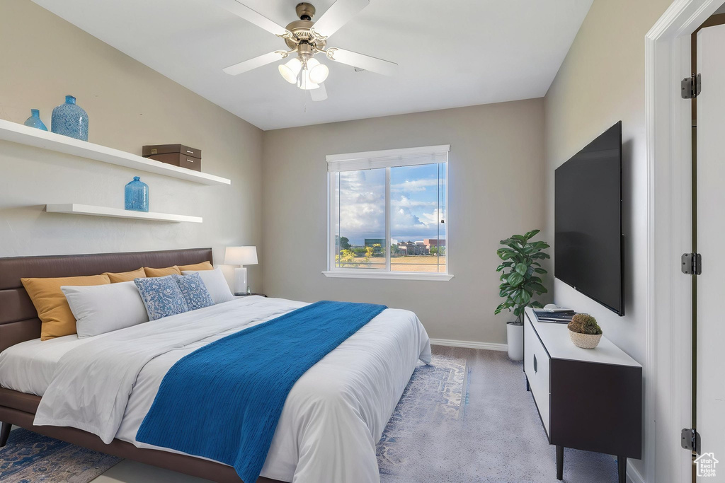 Carpeted bedroom featuring baseboards and a ceiling fan