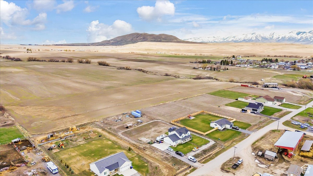 Aerial view of property and surrounding area featuring a mountain backdrop
