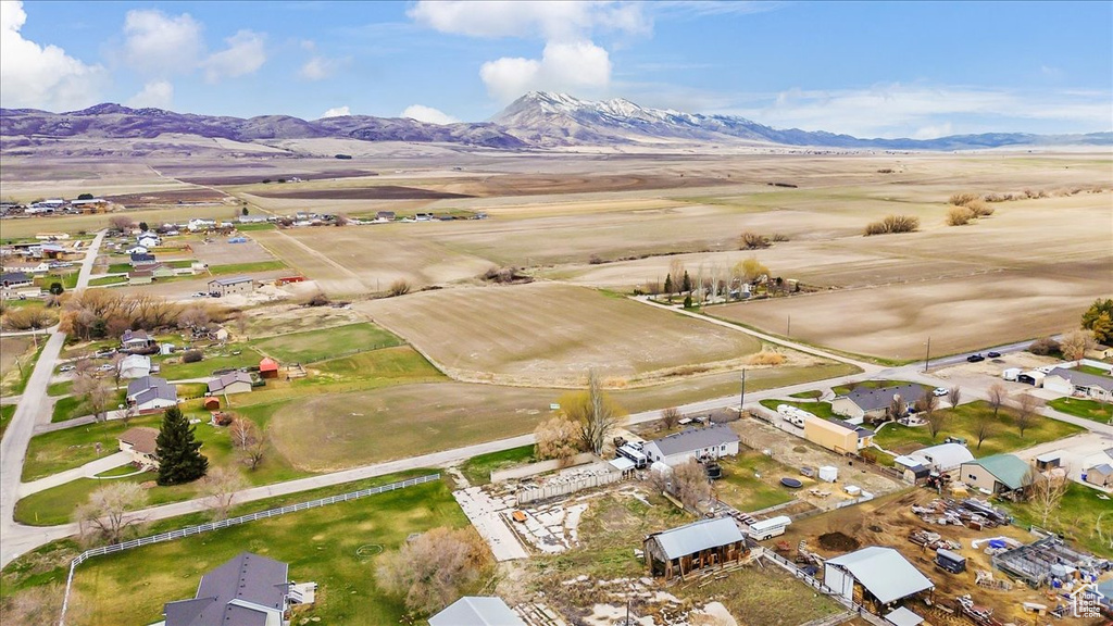 Aerial view of property and surrounding area featuring mountains and nearby suburban area