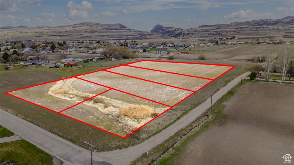Aerial overview of property\'s location featuring a mountainous background and property parcel outlined