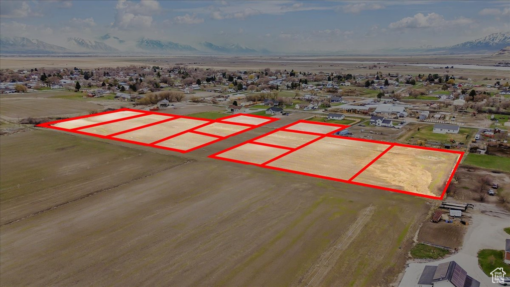 Aerial view of property and surrounding area featuring property parcel outlined and a mountain backdrop