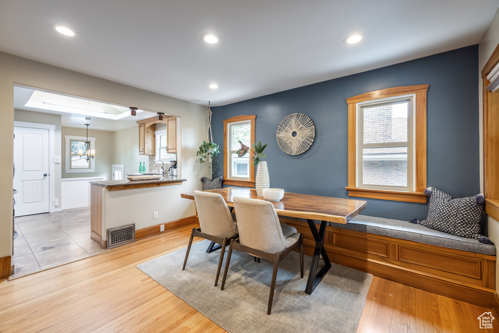 Dining room with recessed lighting, a chandelier, light wood finished floors, and baseboards