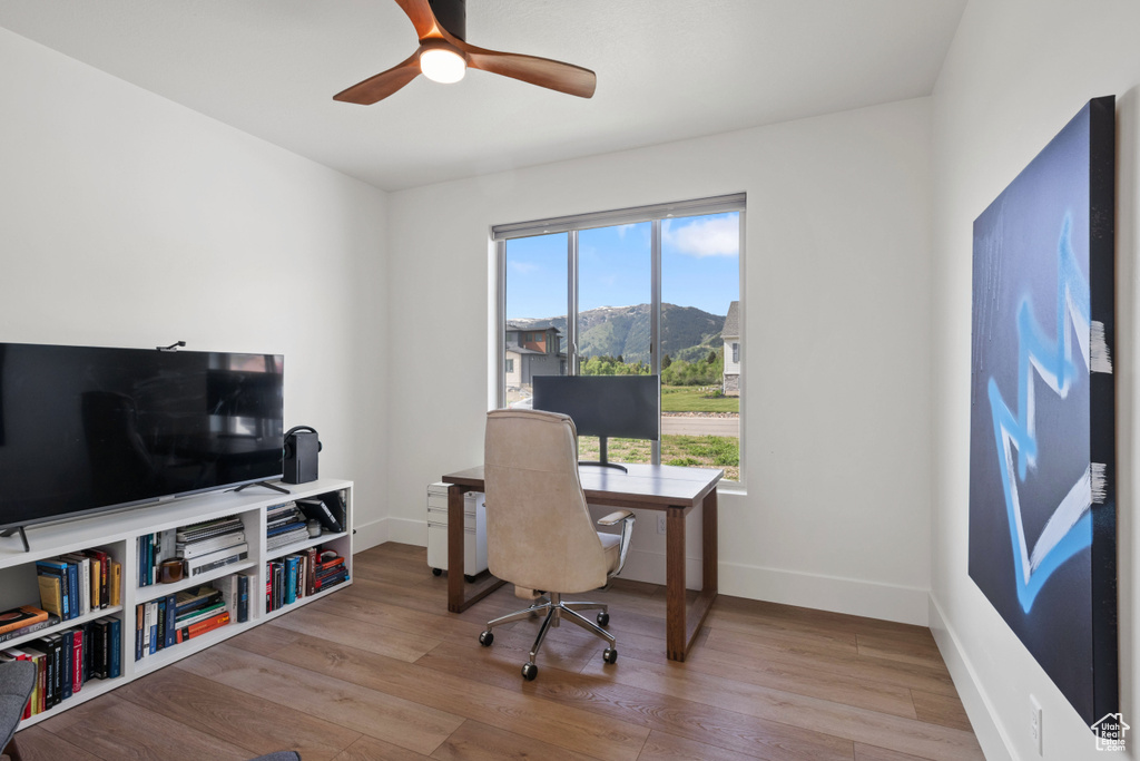 Home office with wood finished floors, baseboards, and ceiling fan