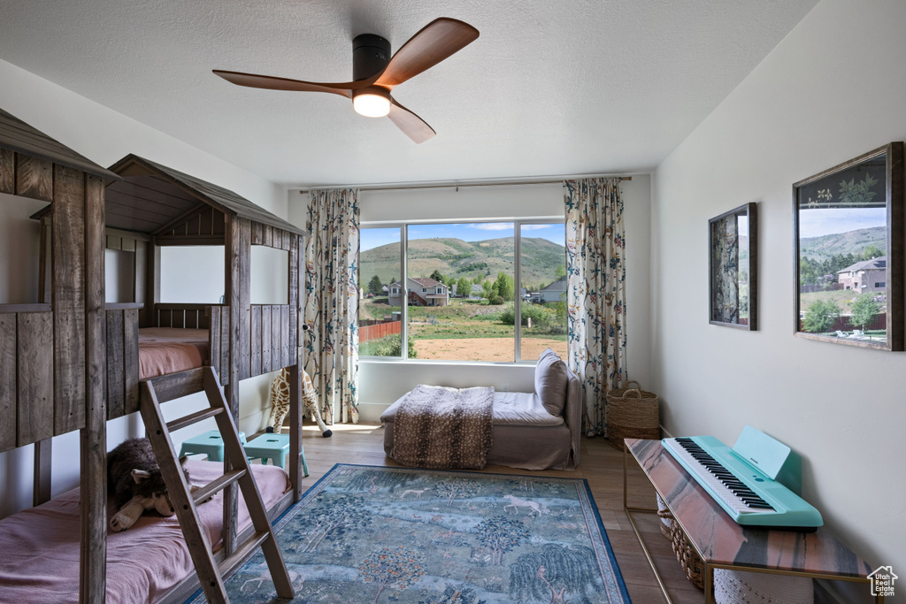 Living area featuring a ceiling fan, wood finished floors, and a mountain view
