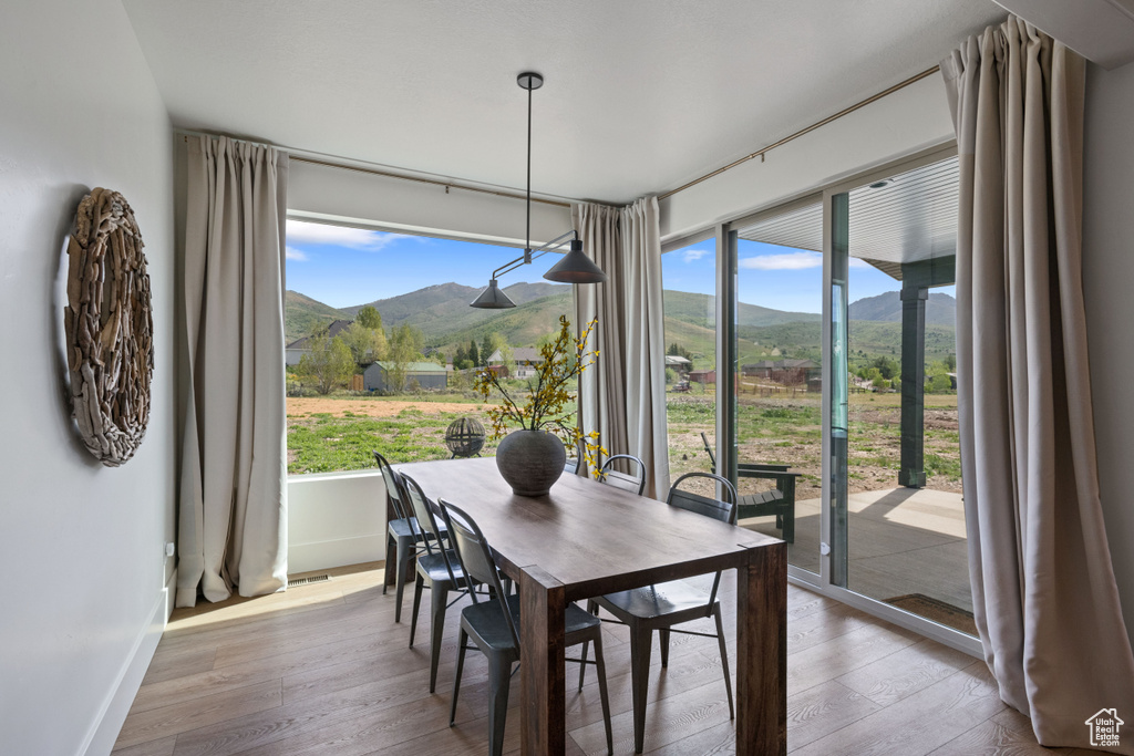 Dining space featuring a mountain view, wood-type flooring, and baseboards