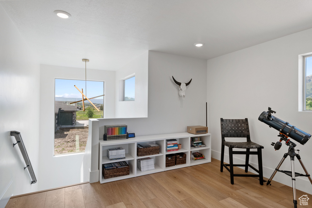 Living area with wood finished floors, plenty of natural light, recessed lighting, and a chandelier