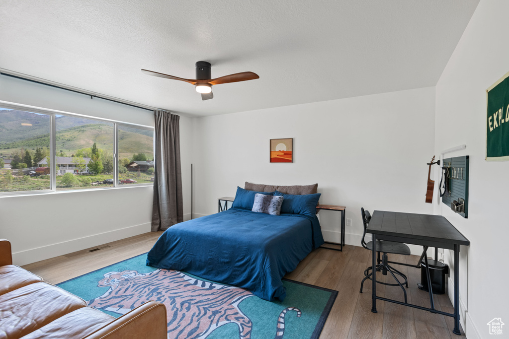 Bedroom with wood finished floors, baseboards, and a ceiling fan