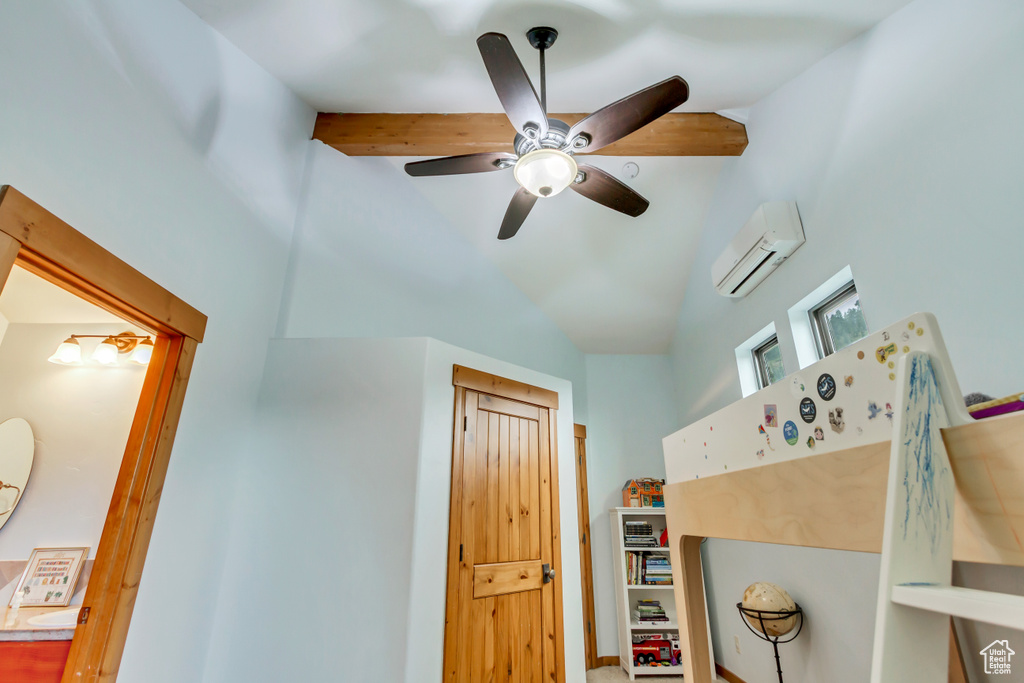 Bedroom featuring a wall unit AC, lofted ceiling, and a ceiling fan