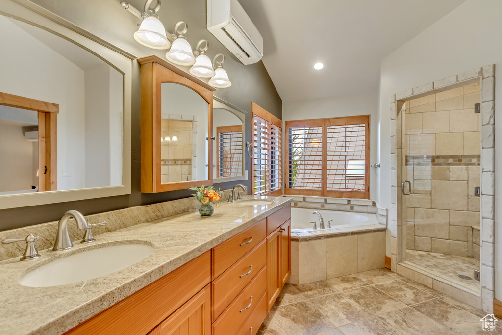Bathroom with an AC wall unit, a bath, a stall shower, and double vanity