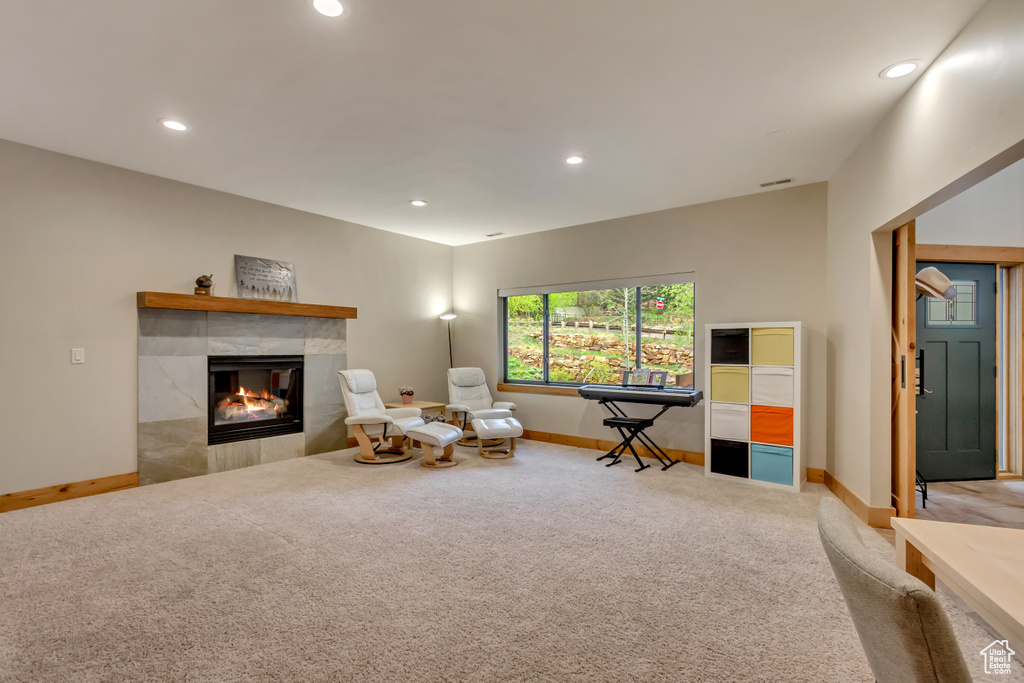 Sitting room featuring carpet flooring, baseboards, recessed lighting, and a tile fireplace