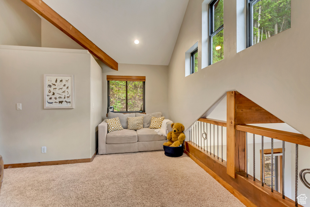 Living room with plenty of natural light, carpet floors, high vaulted ceiling, baseboards, and recessed lighting