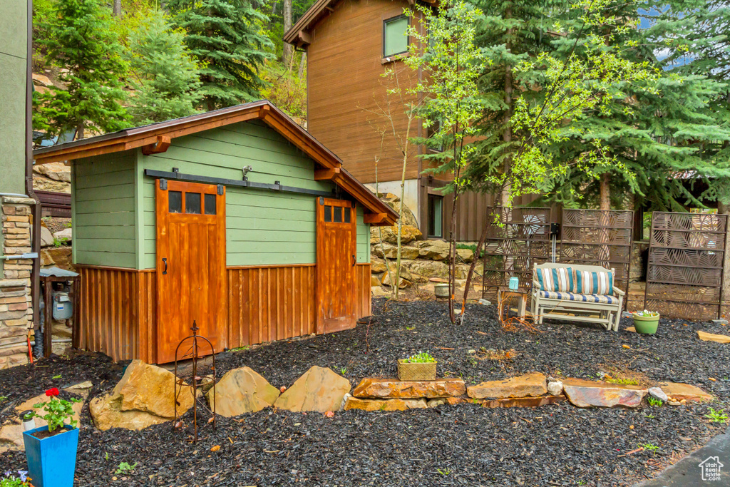 View of side of home featuring fence and an outdoor structure