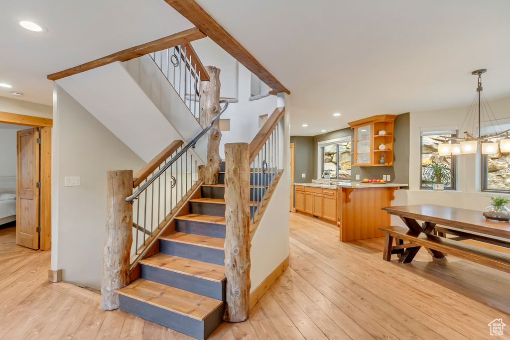 Stairs featuring wood-type flooring, a chandelier, and recessed lighting