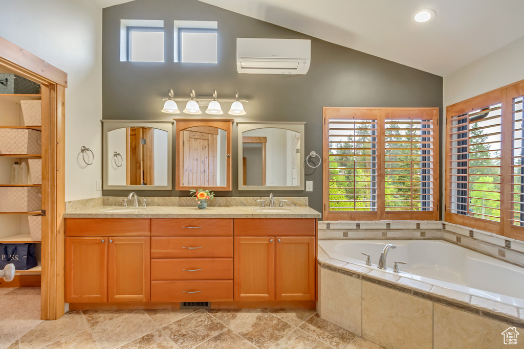 Bathroom featuring high vaulted ceiling, a wall unit AC, healthy amount of natural light, and a bath