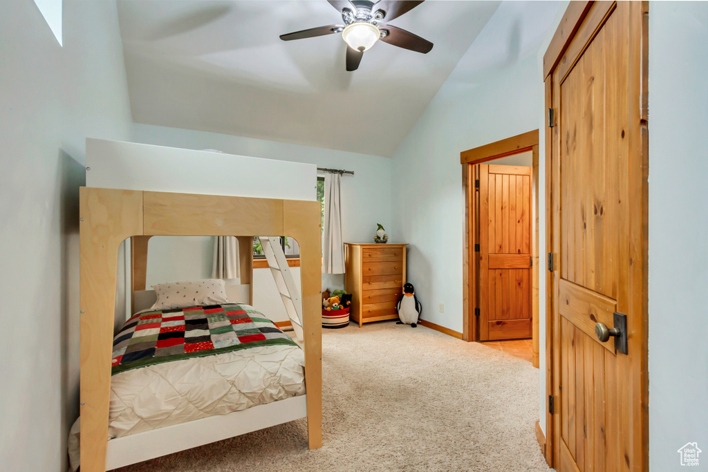 Carpeted bedroom featuring lofted ceiling, a ceiling fan, and baseboards