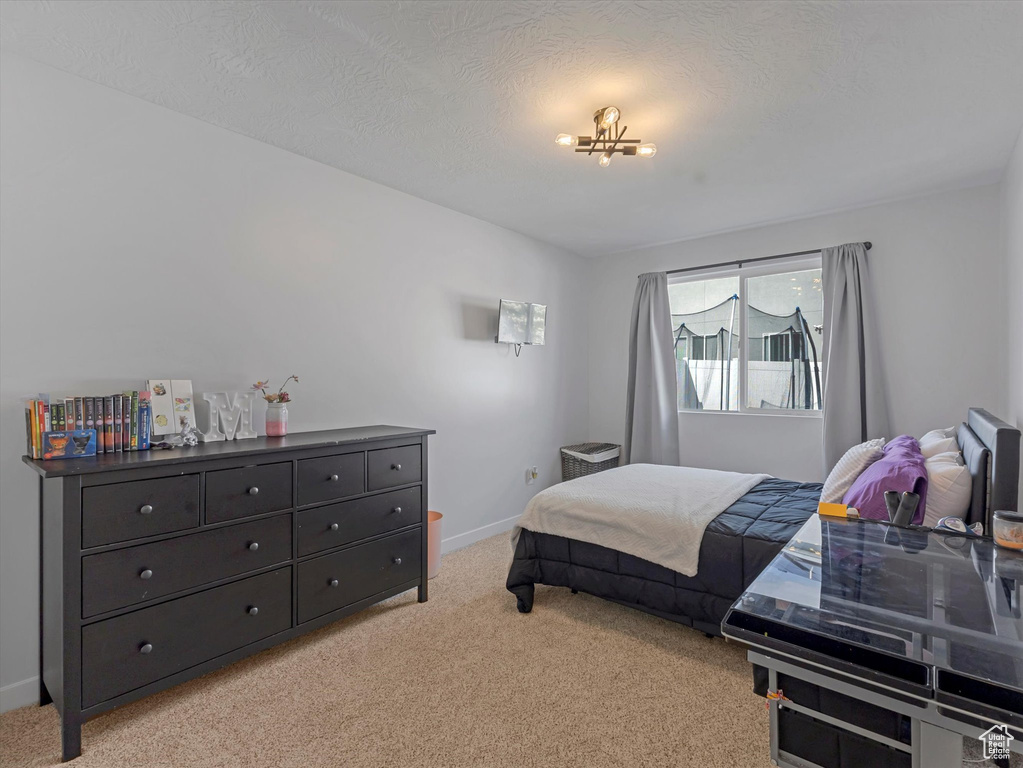 Bedroom with light colored carpet and baseboards