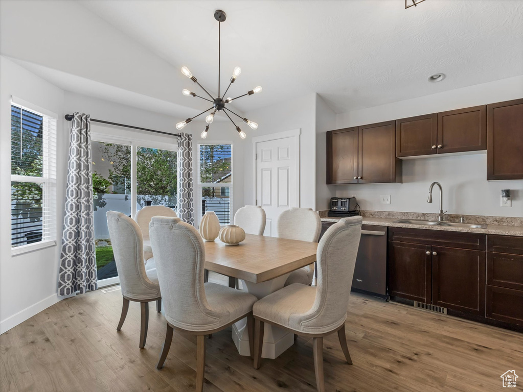 Dining area featuring a chandelier, light wood finished floors, and baseboards