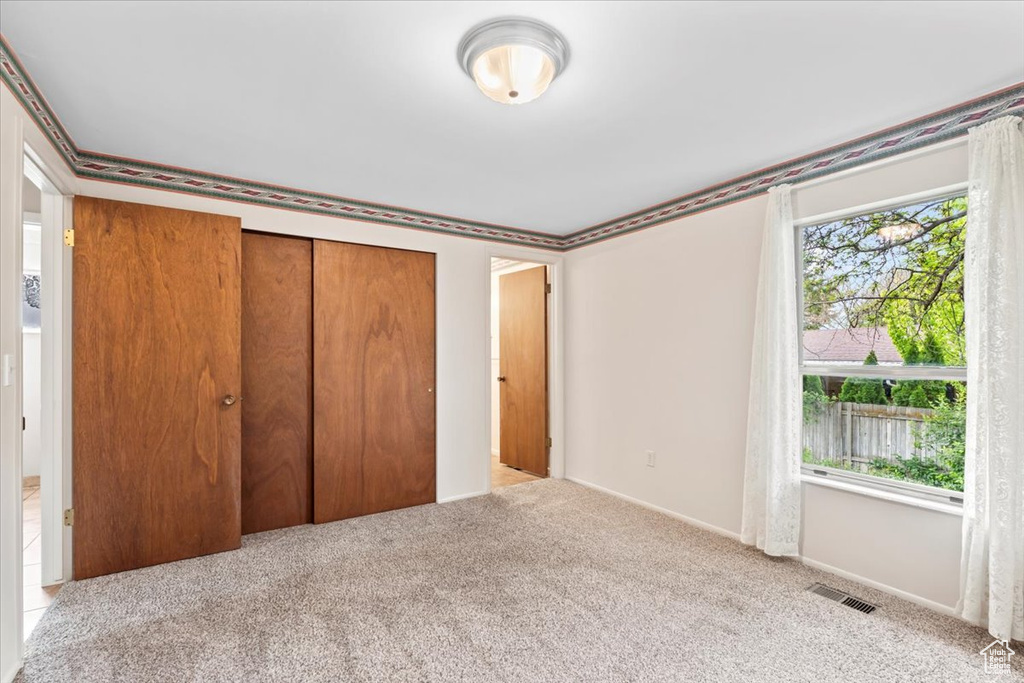 Unfurnished bedroom featuring carpet floors, a closet, and baseboards