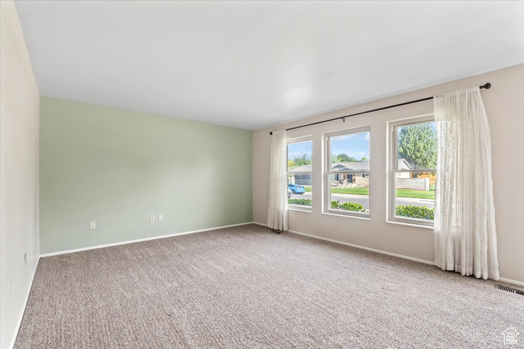 Empty room with carpet floors and baseboards