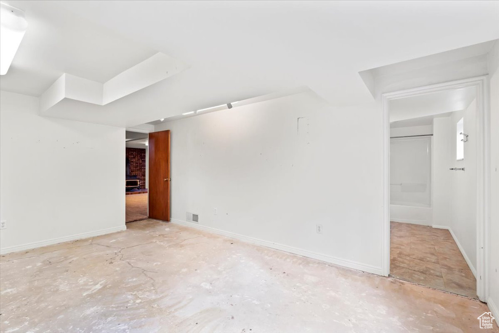 Unfurnished living room with baseboards and concrete flooring