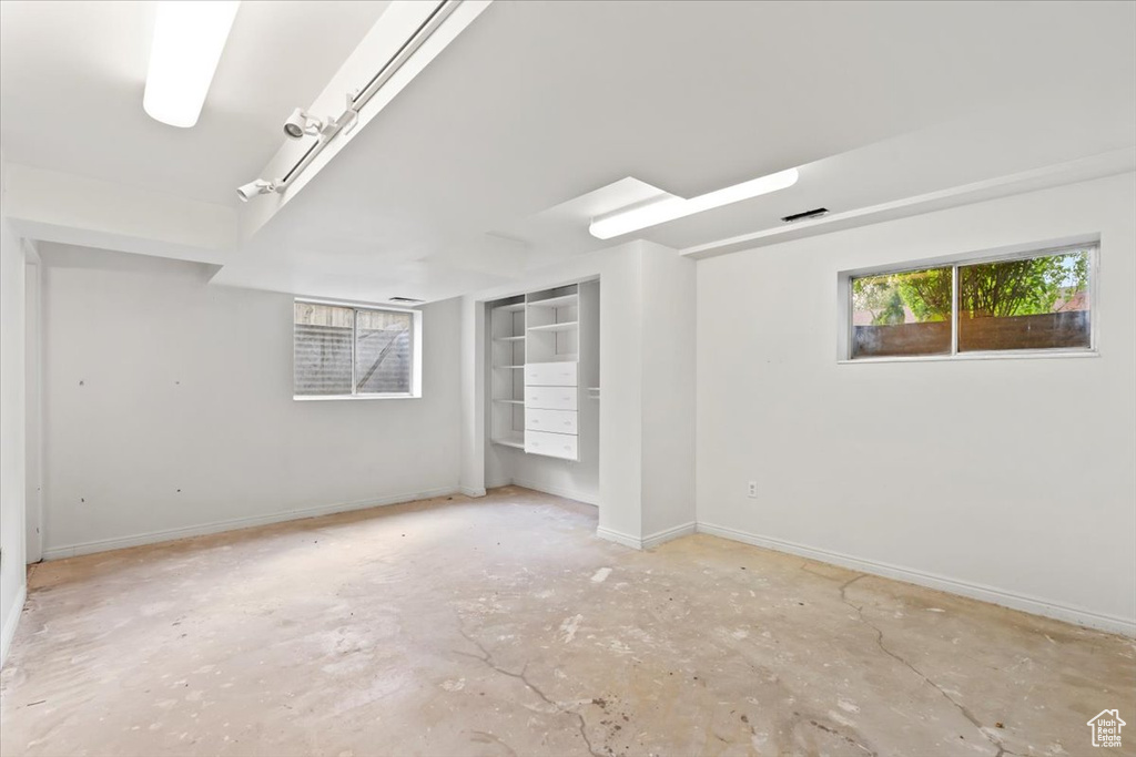 Unfurnished room featuring baseboards and unfinished concrete flooring